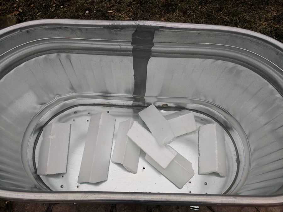 styrofoam lining the bottom of water trough planters